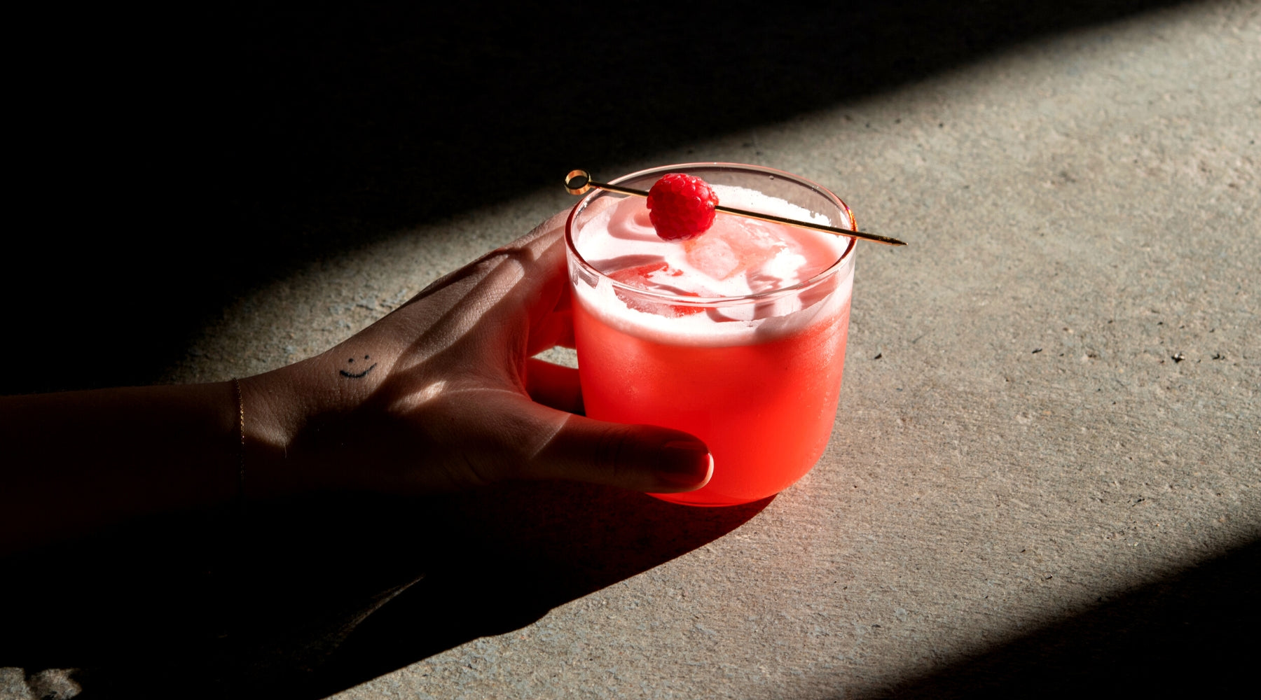 alkoholfreier Cocktail mit Himbeeren und Flasche Laori Juniper No 1