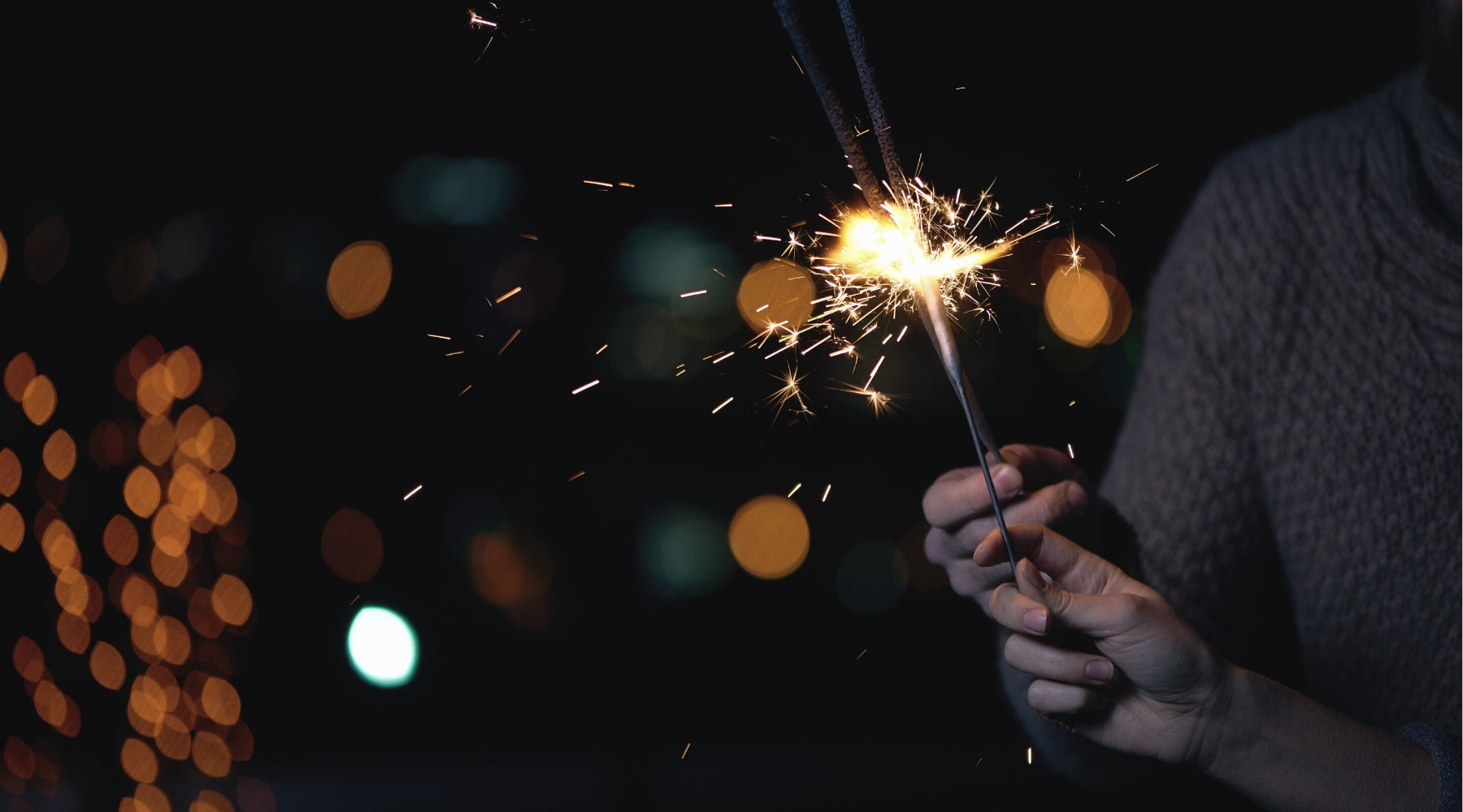 Hände halten Wunderkerzen an Silvester